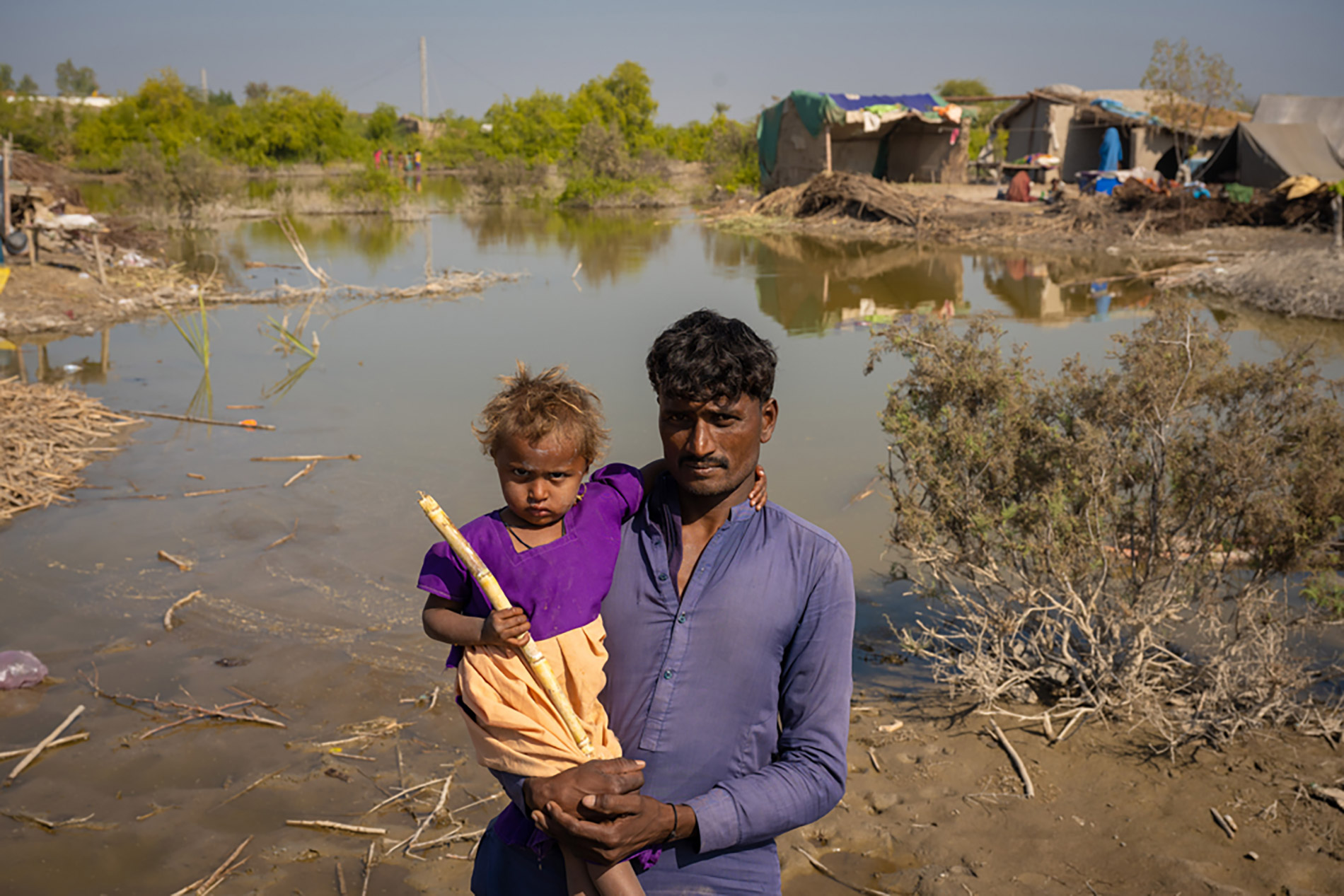 Mann med barn på armen i pakistan